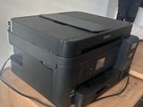 a black printer sitting on top of a wooden table