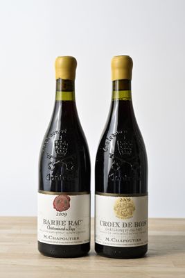deux bouteilles de vin posées l'une à côté de l'autre sur une table en bois