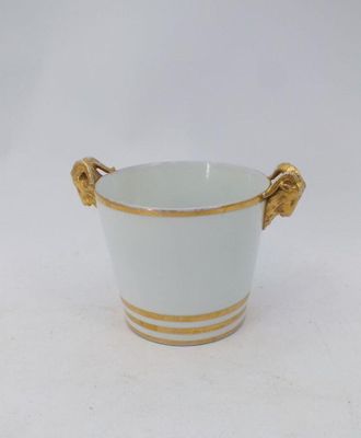 un vase blanc orné d'anses dorées sur un fond blanc