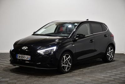 the black car is parked in a room with a checkered floor