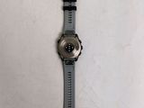 someone is holding a watch on their wrist on a white surface