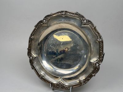un plat ancien en argent orné d'un oiseau, posé sur un socle