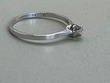 a silver ring with a flower on it on a table