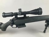 a rifle on a tripod with a scope on it
