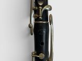 an old clarinet with a black case sitting on top of a white surface