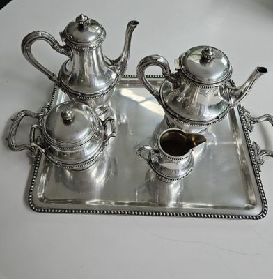 two silver teapots on a tray on a table