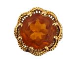 a close up of a ring with an orange stone in it