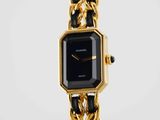 a close up of a watch with a chain around it