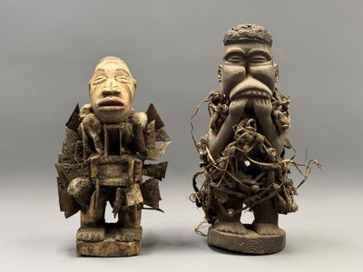 deux statues en bois sculpté représentant deux hommes, avec des visages et des bras