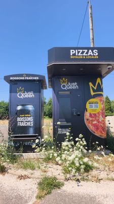 deux boîtes noires sur lesquelles étaient dessinées des pizzas, au bord de la route