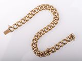 a close up of a gold chain on a white surface