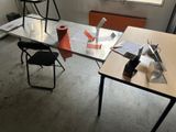 a desk with a chair and a table with a roll of paper on it