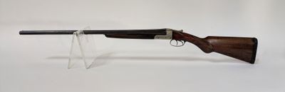 un fusil posé sur un support, devant un fond blanc