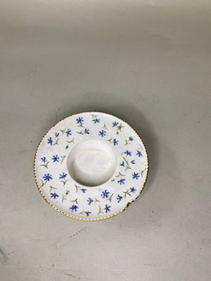 une assiette blanche ornée de fleurs bleues, posée dans un évier