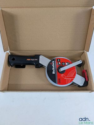 une boîte contenant un outil, posée sur une surface blanche