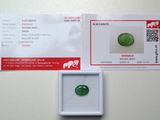 un gros plan sur une pierre de jade verte dans une boîte blanche