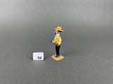 figurine of a man in a yellow hat standing next to a white square
