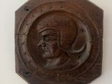 a wooden plaque with a picture of a man on it