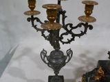 deux chandeliers noirs et dorés posés sur une table