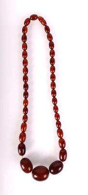 gros plan d'un collier de perles rouges sur fond blanc