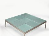 une table basse en verre avec des pieds en métal et un plateau carré en verre