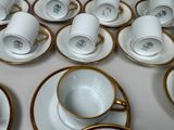 a lot of cups and saucers sitting on a table