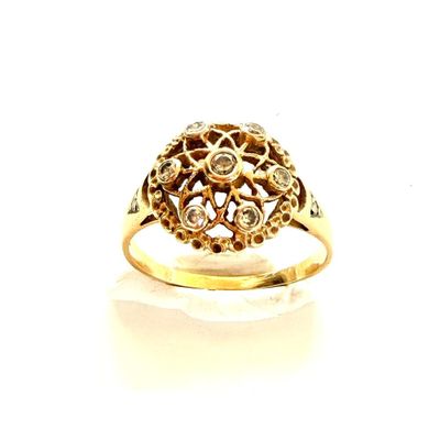 gros plan d'une bague en or avec des diamants sur une surface blanche