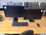 a desk with two monitors and a keyboard on it