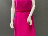 the mannequin is wearing a bright pink dress with a red belt