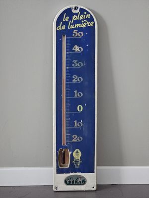 un thermomètre bleu et blanc accroché au mur
