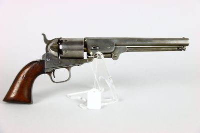 un vieux pistolet avec une poignée en bois sur une surface blanche