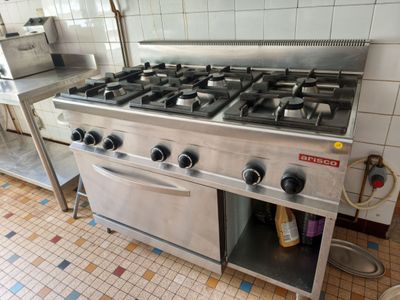 a stainless steel stove top in a kitchen with tile flooring