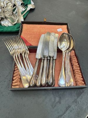 a tray of silverware on a table with other silverware on it