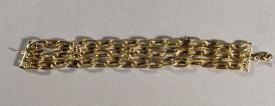a close up of a gold chain bracelet on a white surface