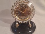 une horloge posée sur un support sur une table