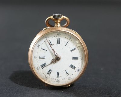 une montre de poche en or avec des chiffres romains sur le cadran