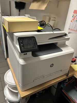 une imprimante posée sur une pile de plaques