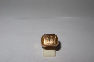 une image représentant une bague en or posée sur une surface blanche
