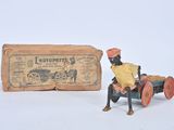 toy figurine of a man sitting on a cart next to a box of cigarettes