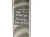 an old book with a black cover and gold lettering on a white background
