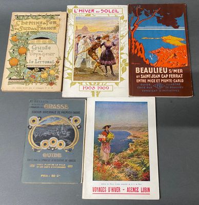 Plusieurs livres sont alignés sur une table devant un fond gris.