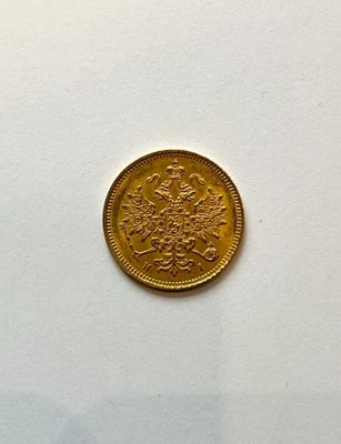 a gold coin sitting on top of a white table