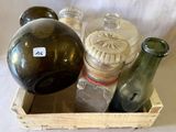 une caisse en bois remplie de bouteilles et de bocaux en verre