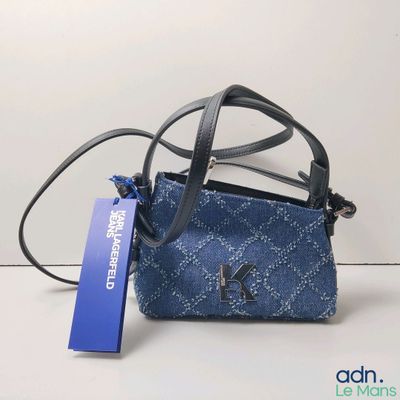 un sac à main bleu muni d'une étiquette, posé sur une table