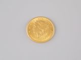 a close up of a gold coin on a white surface