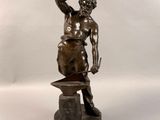 statue en bronze représentant un homme tenant un marteau, posée sur un socle en marbre