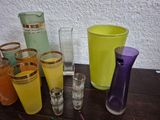 many different colored glassware on a table next to each other