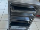 a metal cart with trays on it in a kitchen