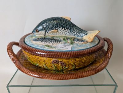 un bol orné d'un poisson, posé sur une étagère en verre