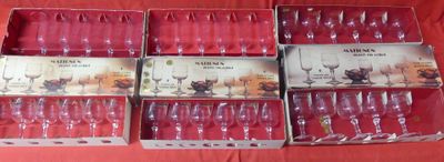 several empty wine glasses in a box on a red table cloth